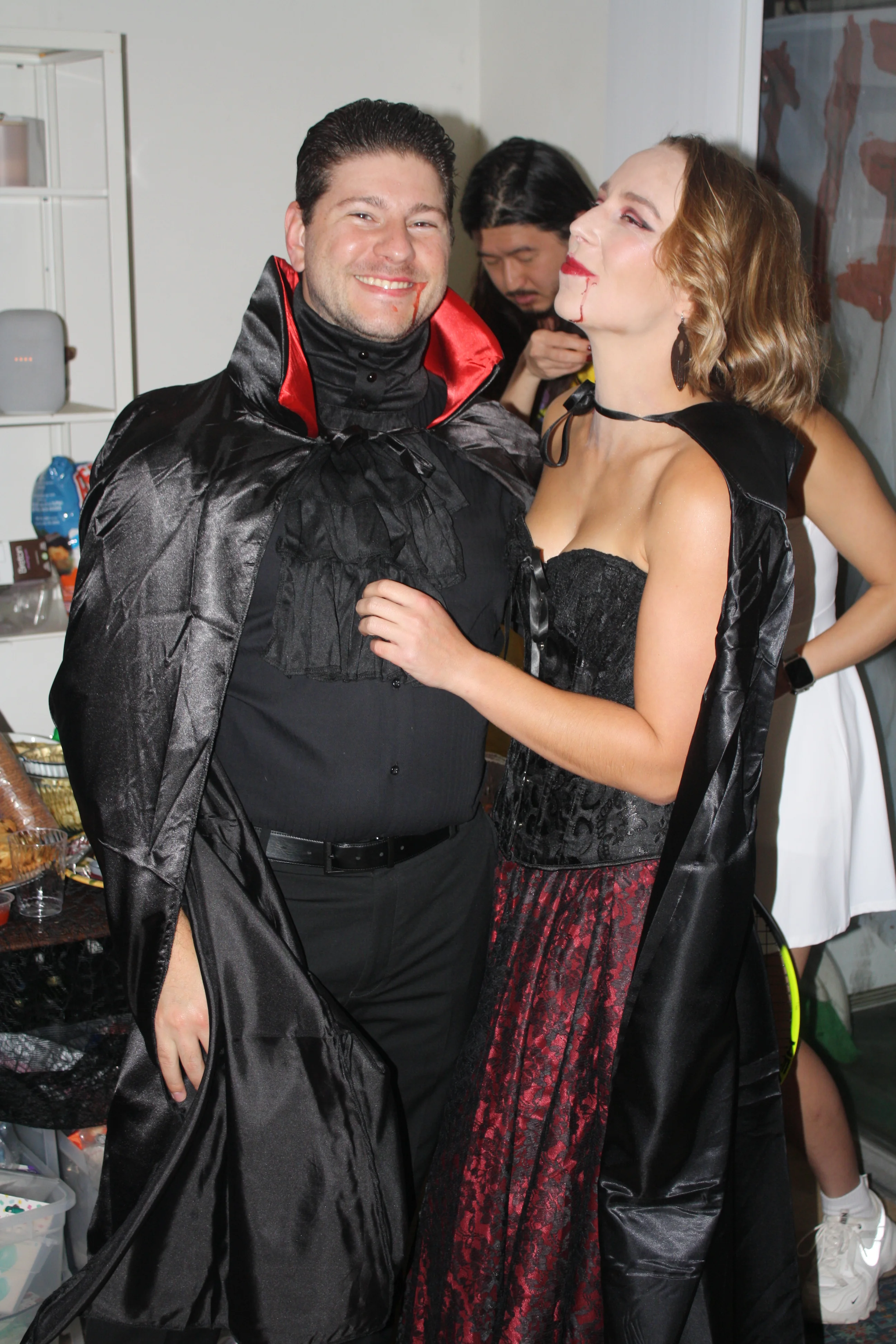 A couple posing in vampire costumes